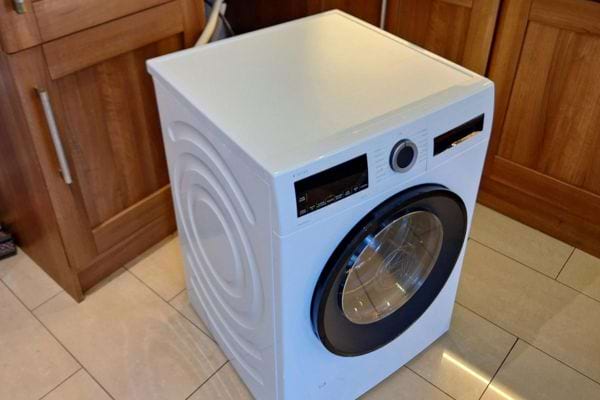 Machine à laver moderne installée dans une cuisine.