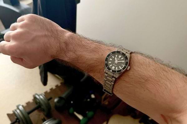 Montre de plongée noire portée à droite, ambiance sport.