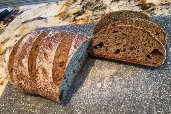 Pain complet tranché sur une planche de cuisine.