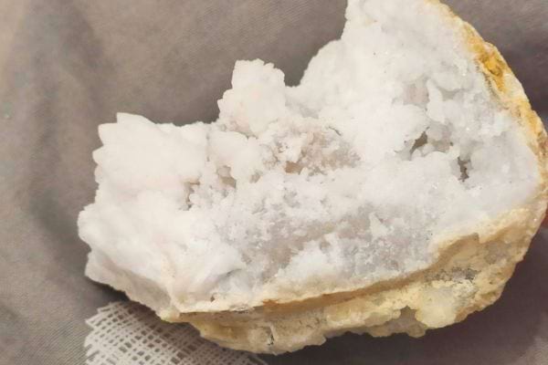 Pierre blanche texturée posée sur tissu.