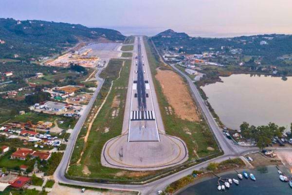 Longue piste encadrée de routes et de maisons, au bord de l’eau.