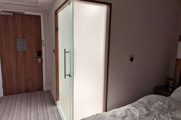 Chambre avec porte vitrée et lit visible.