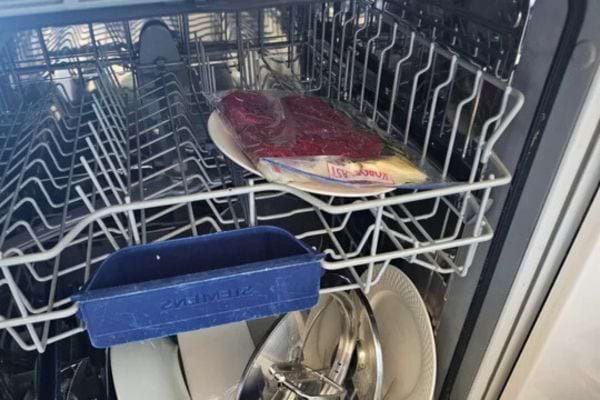 Steak emballé sous vide posé sur une assiette dans le lave-vaisselle.