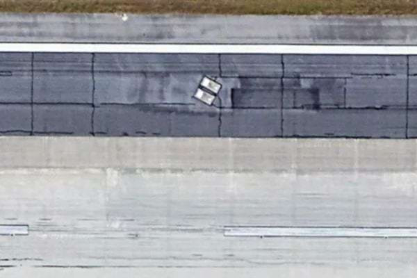 Gros plan aérien des deux tombes sur l’asphalte.