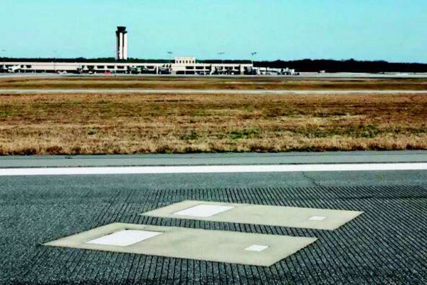 Tombes visibles à même la piste, près d’un aéroport.