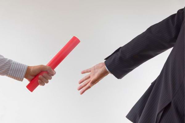 Maison miniature avec loupe et calculatrice pour investissement.