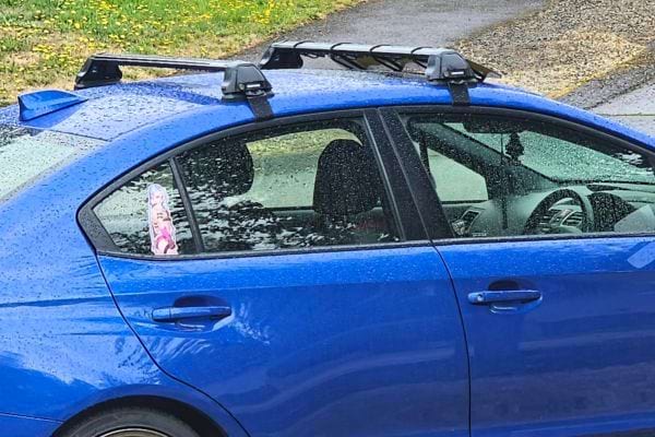Voiture bleue garée sous la pluie.