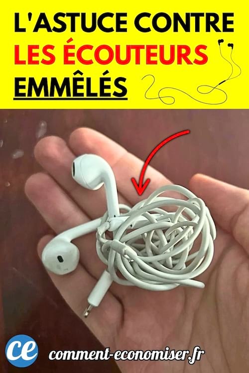 Main tenant une paire d'écouteurs blancs complètement emmêlés.