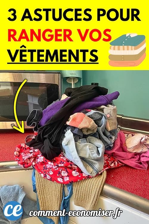 Tas de vêtements non pliés sur une table rouge à côté d’un four et d’un évier