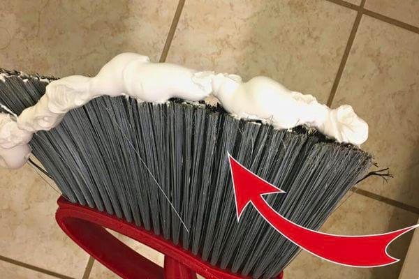 Mousse déposée sur un balai pour nettoyer le carrelage.