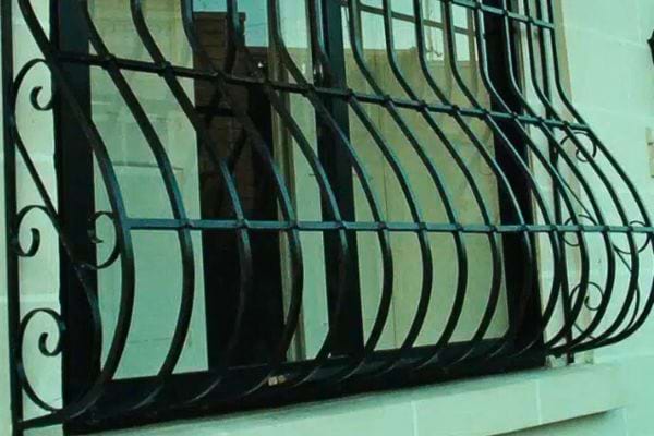 Barreaux arqués serrés sur fenêtre moderne.