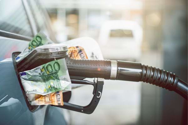 Des billets de 100 € sont insérés dans une trappe à essence.