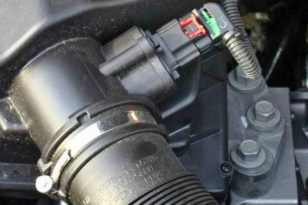 Capteur de débit d’air bien installé avec fil vert visible.