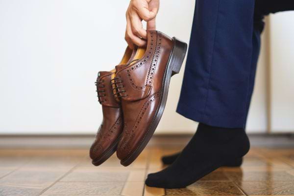 Homme prenant ses chaussures cirées.
