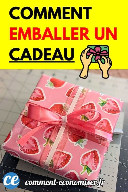 Un joli cadeau emballé dans un papier rose à motifs de fraises et orné d’un ruban satiné, illustrant une idée d’emballage cadeau.