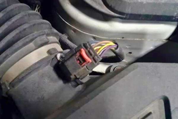Connecteur d’air sale fixé à une pièce du moteur.