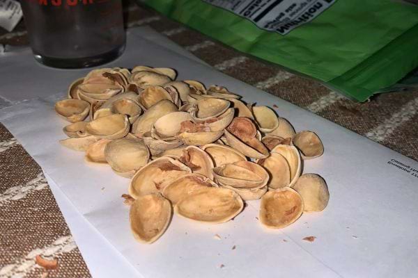 Des coques de pistache sur deux enveloppes blanches