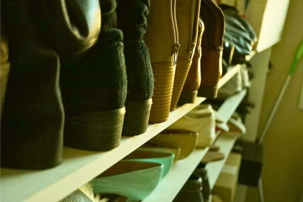 Des chaussures sont rangées côte à côte sur une étagère.