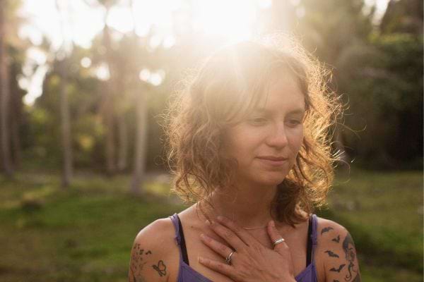 Femme paisible les mains sur le cœur.