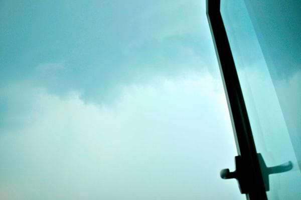 Fenêtre entrouverte sous un ciel orageux menaçant.