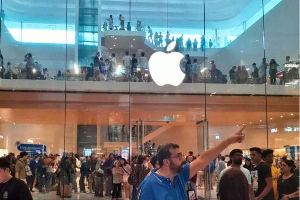 Foule rassemblée devant un Apple Store à deux étages.