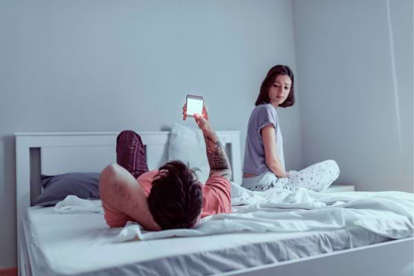 Homme au lit, ignore sa partenaire.