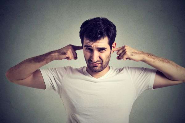 Homme bouche ses oreilles, exaspéré.