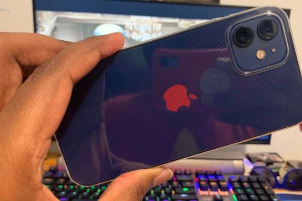 iPhone bleu avec un logo Apple rouge, tenu en main.