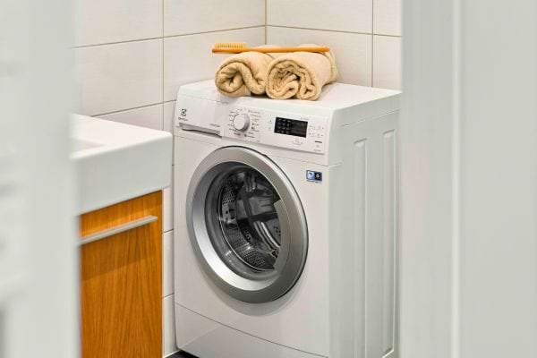 Lave-linge moderne dans une salle de bain, prêt à l’emploi.