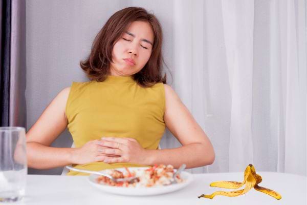Femme a mal au ventre après avoir mangé.