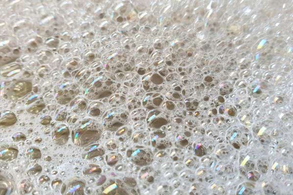 Mousse blanche épaisse avec reflets nacrés.