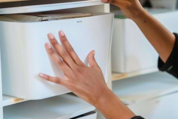 Boîte blanche rangée dans une étagère.