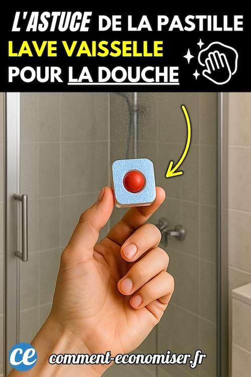 Main tenant une pastille lave-vaisselle bleue et rouge devant une cabine de douche vitrée.