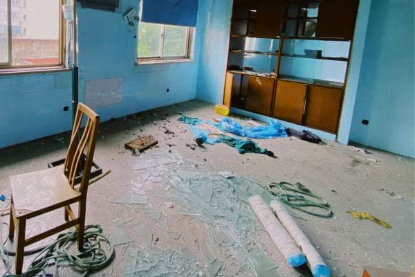 Pièce bleue en désordre, sol jonché de débris.