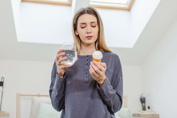 Femme regardant une boite de medicaments