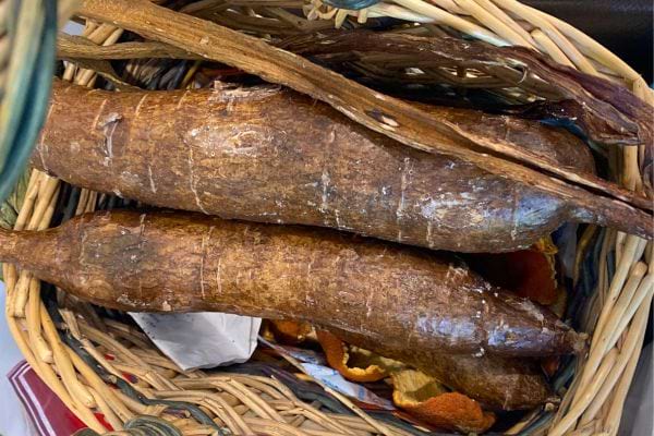 Manioc non épluché dans un panier tressé.