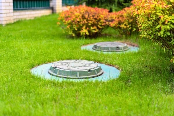 Pelouse avec regards d’égouts discrets dans un jardin.