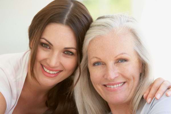 Mère et fille sourient tendrement, visage contre visage.