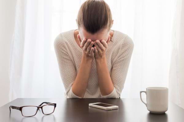 Femme en detresse avec les mains sur le visage
