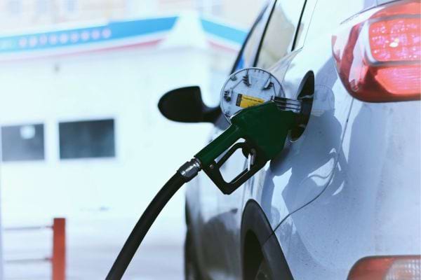 Une voiture se fait ravitailler en carburant à la pompe.