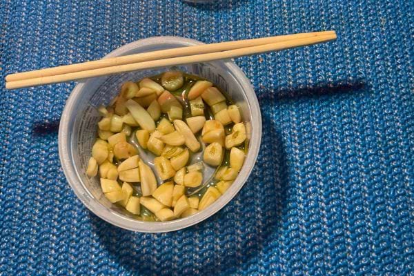 Ail cru coupé en morceaux dans un petit bol.