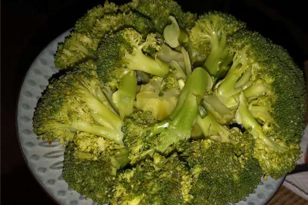 Brocolis cuits servis dans une assiette blanche.