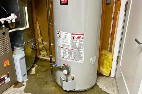 Chauffe-eau récent gris clair installé dans un sous-sol.