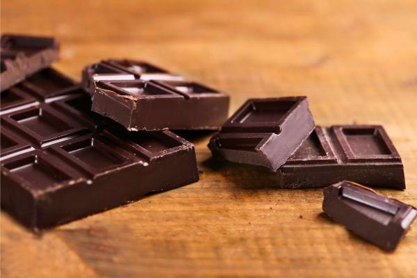 Morceaux de chocolat noir sur une table en bois.