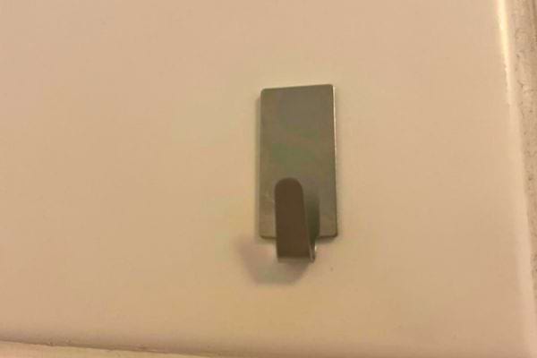 Crochet mural vide sur un carrelage.