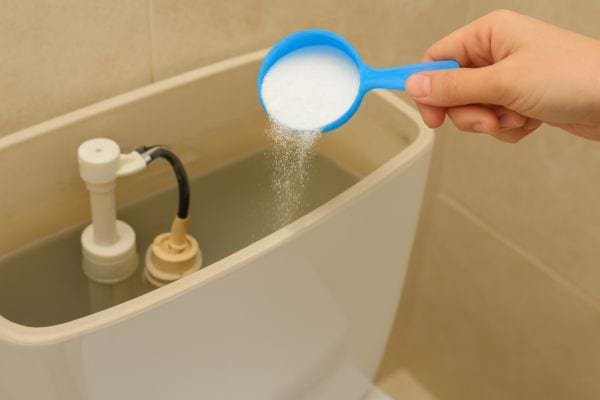 Une cuillère de bicarbonate est ajoutée dans le réservoir.