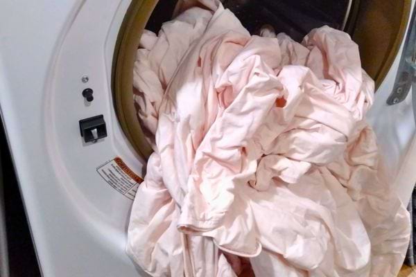 Draps rose pâle sortant d’une machine à laver.