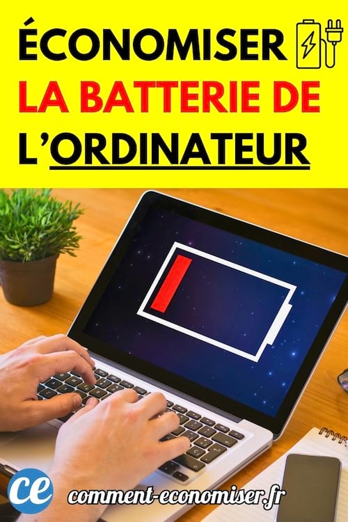 Ordinateur portable affichant une batterie presque vide sur un bureau avec une plante et un carnet.