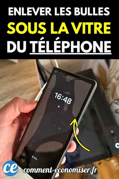 Smartphone noir tenu en main avec des bulles visibles sous la vitre de protection.