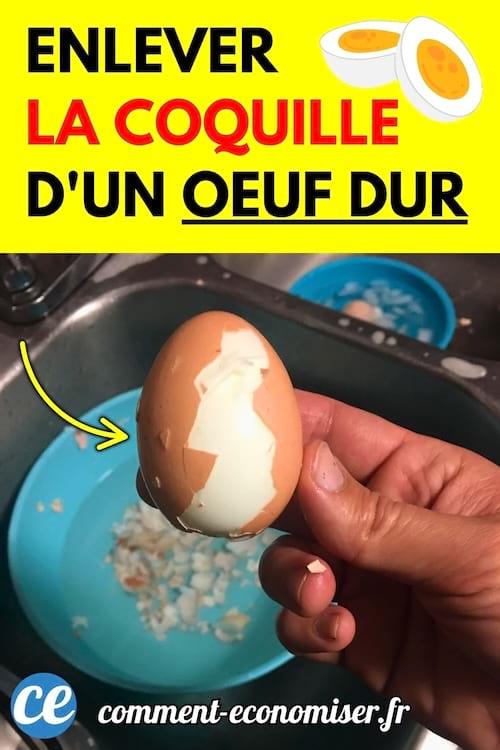Un œuf dur partiellement écalé tenu à la main au-dessus d’un évier, avec des coquilles dans une bassine bleue.
